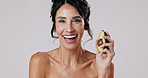 Woman, face and skincare with avocado in studio for natural treatment, facial wellness and organic transformation. Smile, female person and fruit for dermatology, nutrition glow and white background