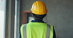 Man, back and walking for construction, inspection and contractor compliance on site with helmet. Safety manager, maintenance and quality assurance for renovation, engineering or project management