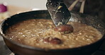 Cooking, stirring and person in kitchen for recipe, culinary skills or pan on stove. Closeup, mushrooms and rice in dish for preparation, risotto process and chef in home for private class in cuisine