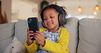 Girl, child and phone for sound in home, watching video and listening to podcast for learning. Female person, kid and playing games in living room for mind development, happy song and streaming audio