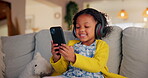 Girl, child and phone for music in home, watching video and listening to podcast for learning. Female person, kid and playing games in living room for mind development, happy song and streaming audio