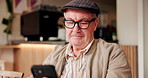 Coffee shop, morning and senior man with phone for internet, online games and chat in cafe. Retirement, happy and elderly person on smartphone in restaurant, cafeteria and diner waiting for service