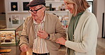 Senior, couple and customer in cafe with shopping for cookie choice, muffin breakfast and option. Elderly, people and happy in coffee shop for morning caffeine, bonding and conversation on lunch date