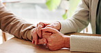 Holding hands, support and senior couple by table for love, empathy or forgiveness in marriage. Unity, home and elderly man and woman with connection for trust, loyalty and care for bonding together.