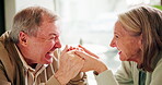 Elderly couple, holding hands and laughing in conversation with smile for marriage, bonding and love. Happy, senior man and woman with communication at home for connection, care or retirement romance