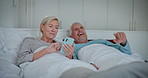 Mature couple, bed and phone with laughing, morning and news app with commitment. Talking, social media and health relationship in home with discussion together in bedroom with happy people and love