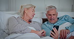 Senior couple, bed and phone with news app, digital scroll and tech learning with help and support. Talking, social media and online in home with discussion together in bedroom with people and love