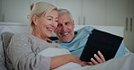 Mature couple, bed and tablet with laughing, digital scroll and tech learning with help and support. Talking, social media and online in home with discussion together in bedroom with people and love