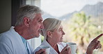 Elderly couple, window and sightseeing with coffee for holiday, vacation or view at nature resort. Mature man, woman or lovers enjoying beverage, breakfast drink or morning together at luxury hotel