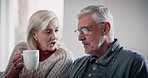 Senior couple, discussion and coffee in home at morning with retirement planning with care. Chat, love and tea with marriage of people in a living room with communication and commitment together