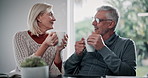 Senior couple, discussion and coffee in home with retirement planning and smile with care. Chat, love and tea with marriage of people in a living room with communication and commitment at morning