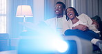 Laughing black couple, eating popcorn and projector for movie, show or comedy film in home. Food, man and woman watching funny drama, talking or relax together in living room for subscription service