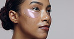 Skincare, woman and face in studio with eye mask, beauty or hyaluronic acid treatment. Girl, thinking and patch on skin for hydration, anti aging and dermatology care on gray background for aesthetic