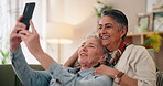 Lesbian couple, relax and happy on sofa for selfie, bonding and commitment in relationship. Mature women, love and smile for photography with affection, kiss or social media update in home with trust