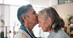 Mature women, love and forehead kiss in home for care, support and trust in relationship. Senior lesbian couple, romantic gesture and affection in living room for security, wellness and commitment