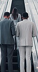 Corporate, people and luggage on escalator for travel, booking flight and schedule of transport journey. Back, staff and suitcase with walk for airplane trip, electric service or global opportunity
