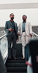 Business, men and talking for travel on escalator with luggage, booking flight and transport journey. People, discussion or suitcase for walk, airplane trip and electric service of global opportunity