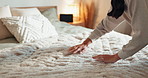 Woman, hands and cleaning bed with sheets, pillows or blanket for tidy house or daily routine at home. Closeup, female person or cleaner with bedding duvet for organized or morning chores in bedroom