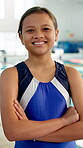 Girl, smile and arms crossed at swimming pool with fitness for training lesson, workout or practice. Portrait, female kid or happy for sports challenge, tournament or swimmer program at indoor centre