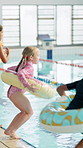 Children, group and jump in pool at swimming lesson with donut for safety, float and splash at class. Kids, together and excited with rubber toys for exercise, learning and development in water