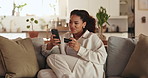 Woman, credit card and relax with phone on sofa for online shopping, payment or banking app at home. Young, female person or shopper with debit or mobile smartphone for ecommerce or purchase at house