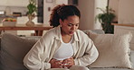 Woman, sofa and stomach ache with pain for menstruation, cramps or period cycle at home. Young, female person or sick girl with tummy bug for indigestion, diarrhea or sore abnominal reflux at house