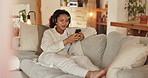 Headphones, phone and woman on sofa in home listening to music, podcast or playlist for blog review. Relax, cellphone and female freelance critic with audio tech for streaming new album at house.