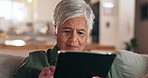 Senior woman, tablet and reading on sofa, texting and thinking with application for contact in home. Person, touchscreen and scroll for movie, ebook and social network with subscription in retirement