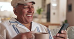 Coffee, happy and senior man with phone on sofa for social media, internet and online reading in home. Retirement, smile and mature person with mug for tea, warm beverage and drink in living room