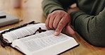 Bible, reading and hands of person in home for gospel lessons, learning and spiritual belief. Religion, Christianity and closeup of holy book for scripture, worship and praying for faith in God