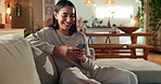 Woman, smartphone and happy with texting on sofa, reading and notification with mobile app in living room. Person, smile and phone on couch for chat, contact and relax with scroll on social network