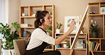 Art, painting and woman with canvas in home with easel for creative artwork, drawing and illustration. Painter, artist and person with for inspiration, expression and design project in apartment