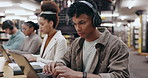 Man, student and headphones with laptop in library for typing assignment essay, study music or exam research. University, group and person with technology for online course, radio audio and education