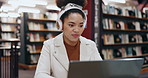 Student, headphones and woman on laptop in library typing for education, university and knowledge. College, music and person on technology for studying research for project assignment and assessment