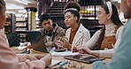 University, people and group in library with laptop for educational discussion, exam preparation or learning. Diversity, students and books for scholarship, knowledge research and assignment teamwork