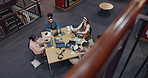 Above, people and tech in library for education, studying and research for exam preparation. Students, group and laptop at table for information, productivity and reading with notes in university