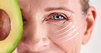 Avocado, eye and wrinkles of mature woman closeup in studio for cosmetic skincare treatment. Face lift, portrait and special effects with person at salon or spa for collagen, dermatology or detox