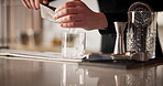 Hands, bartender and ice cube in glass for mixology, whiskey or hospitality with catering in club. Barman, luxury and alcohol drink in hotel for happy hour, prepare or professional person with liquor