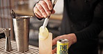 Hands, tongs and bartender with lemon slice in cocktail for drink preparation closeup in pub. Alcohol, glass or barman with fruit on ice to garnish liquor on rocks for decoration, art or presentation