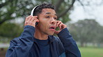 Fitness, park and man with headphones for music, streaming playlist and radio for workout. Sports, nature and person listening to audio for marathon training, exercise and running outdoors for health