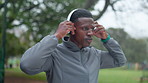Fitness, park and black man with headphones for workout, exercise and running outdoors for health. Sports, nature and person listening to music, streaming playlist and radio for marathon training