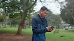 Running, phone and man with headphones in park to listen to music, audio and radio for workout. Sports, smartphone and person with health app for marathon training, exercise and running outdoors