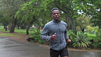 Fitness, running and black man with exercise in nature for cardio, wellness and workout in morning. Athlete, runner and person with challenge in park for sports, endurance and training for marathon