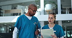 Nurses, man and woman consulting chart for patient info, results or planning schedule for hospital management. Walking, talking and medical team in lobby with folder, checklist or healthcare advice