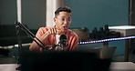Man, podcast and live streaming in studio with presenting or talking to online viewer with microphone. Male person, radio presenter and conversation with listeners on talk show and  broadcast