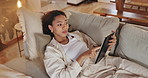 Online, surprise and tablet with woman on sofa for social media, dating profile update and chat post. Network, technology and news with person in living room at home for search, blog and app