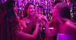 Dancing, cheers and champagne with women in club for new years eve party, celebration and concert. Neon, energy and night with people and toast at disco for freedom, social event and festival