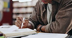 Student, writing and books with  hands of man in library for knowledge, education and college thesis. Academy, future and university with person and studying for exam, project and scholarship