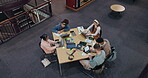 Above, students and laptop in library for education, studying and research for exam preparation. People, group and tech at table for information, productivity and reading with notes in university