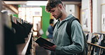 College, student and learning with novel in campus library for book study or history course. University, scholarship and man with reading at academy for knowledge, information or project research